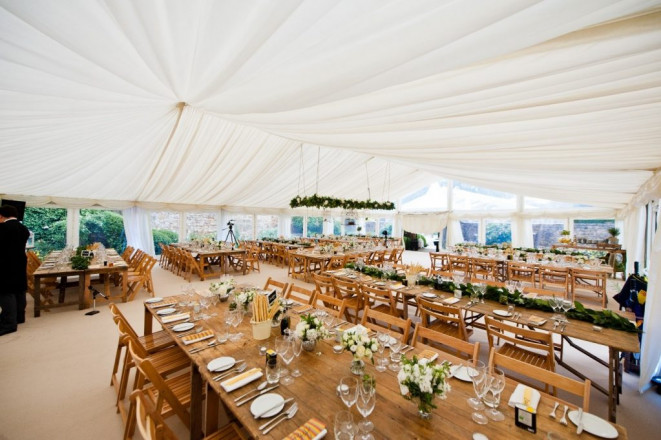 Rustic themed wedding marquee with ivory pleated lining