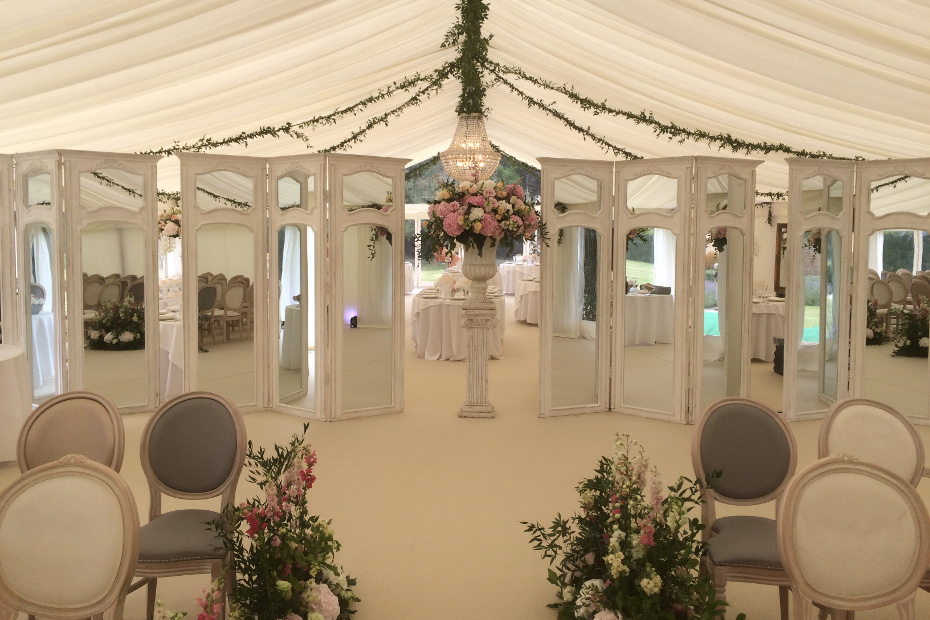 Elegant screening separates the wedding ceremony and reception areas in marquee