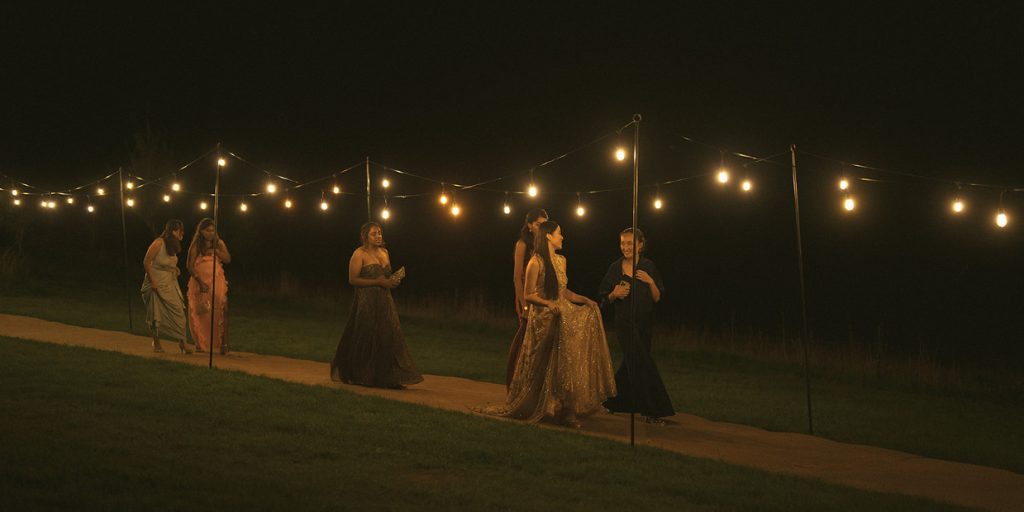 Wedding guests walking down lit pathway